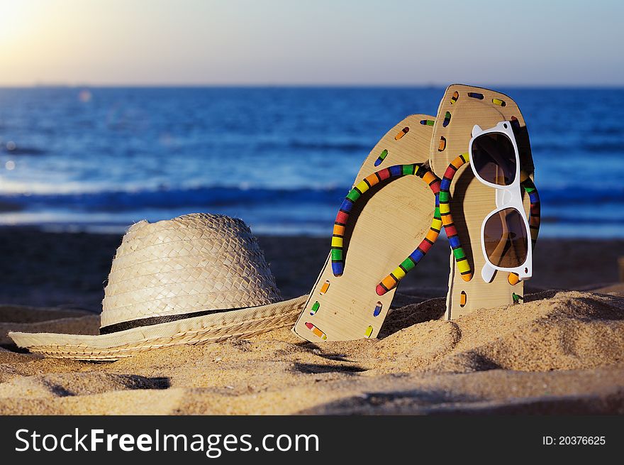 Wicker hat, sandal and glasses on the sandy beach. Wicker hat, sandal and glasses on the sandy beach