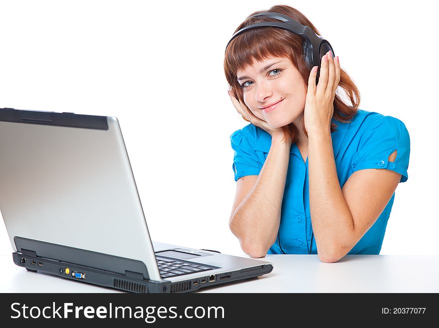 Red-haired teen-girl listen to music in headphones with laptop. Isolated on white background