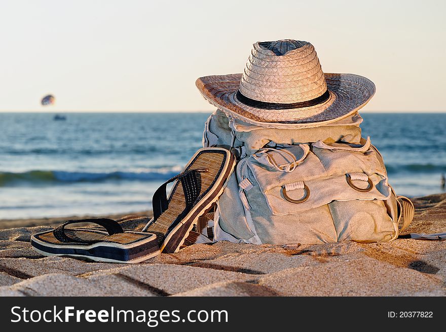Knapsack, hat and sandal on the sandy beach. Knapsack, hat and sandal on the sandy beach