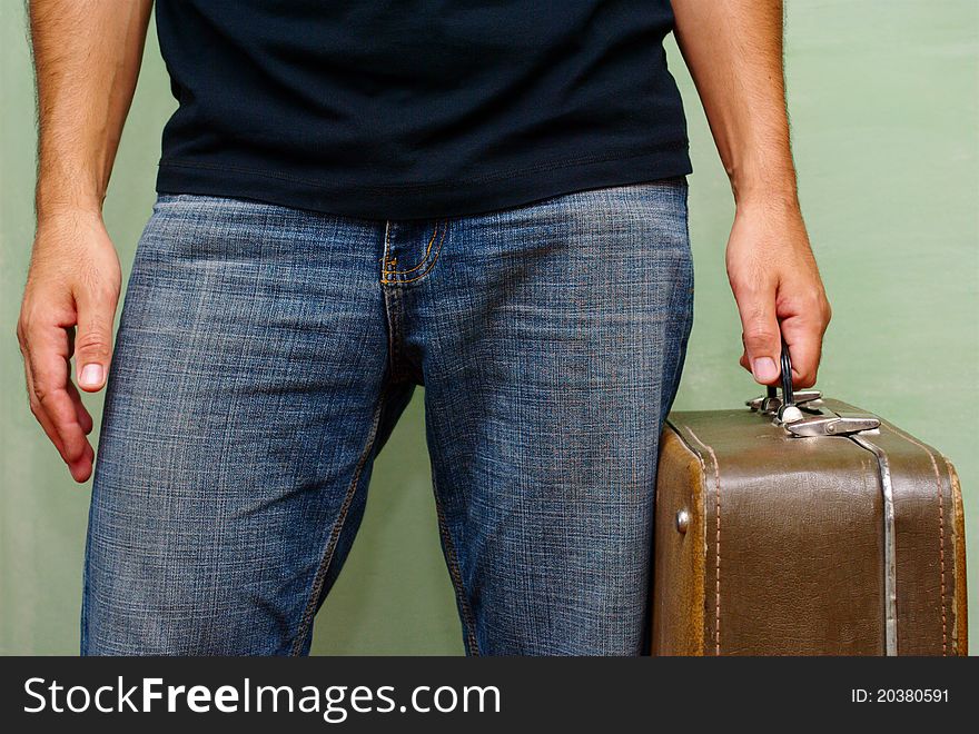 Shabby old suitcase in a man's hand. Shabby old suitcase in a man's hand