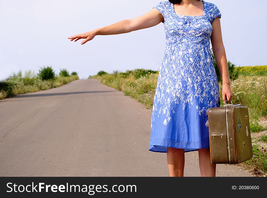 Young Girl On The Road With A Suitcase