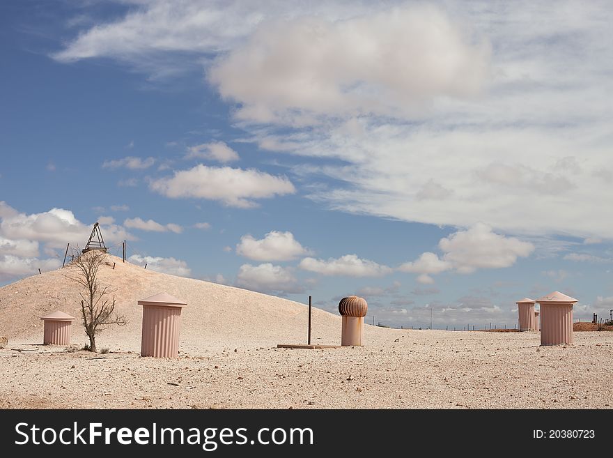 Underground town in desert in cloudy sky