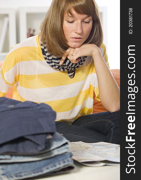 Woman reading travel map before packing
