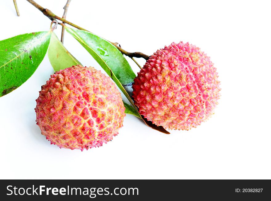 Fresh red lichi fruits with green leaves on a white background