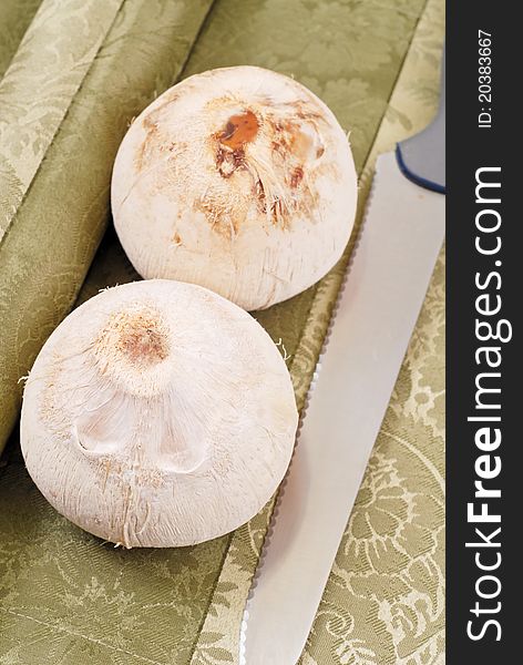 Husked Coconuts With Knife On Table Cloth