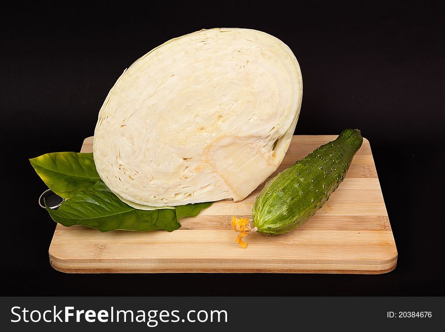 Cabbage and cucumber on wooden table prepared for use