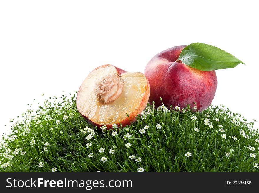 Fresh peach on a green grass isolated on a white background