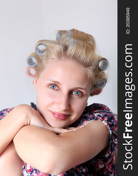 Young woman with hair curlers on her head.