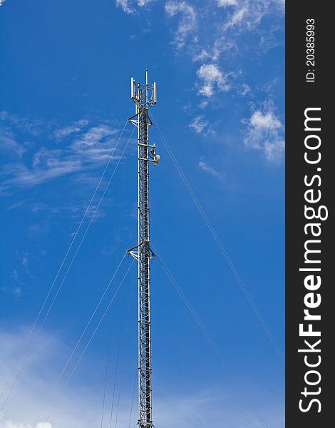 A mobile telephone antenna on blue sky day