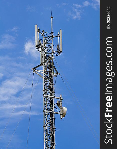 A mobile telephone antenna on blue sky day