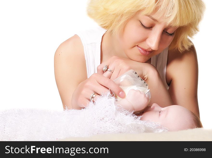 A young mother feeds her baby by the small bottle