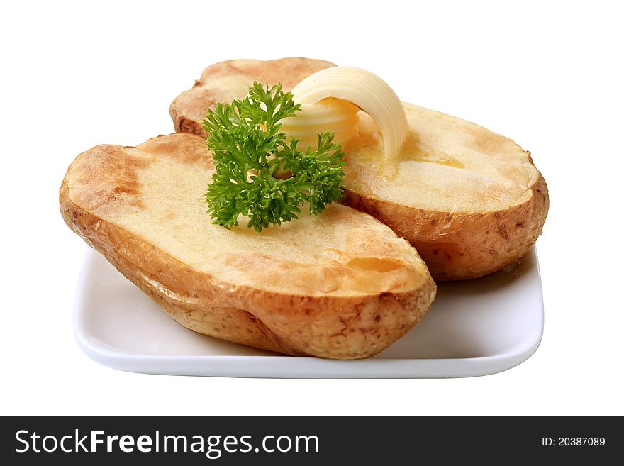 Butter curls melting on a baked potato - cut out on white