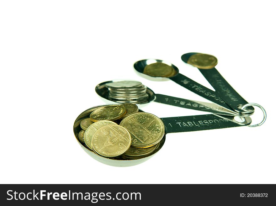 Coin in metal measuring spoon. Coin in metal measuring spoon