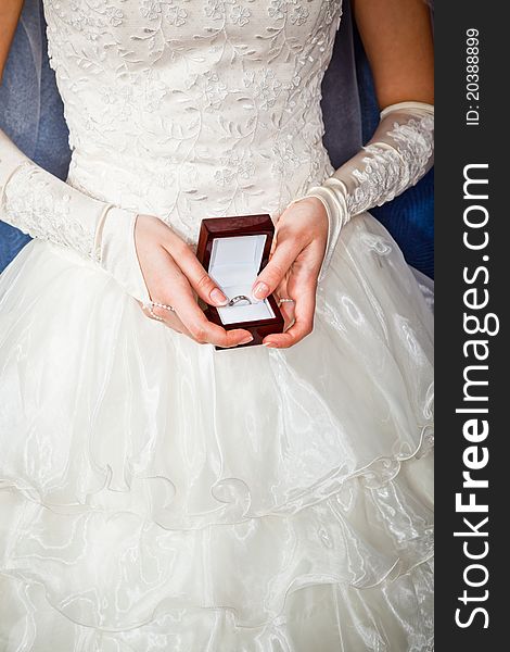 Girl with surprise looks at box with wedding ring