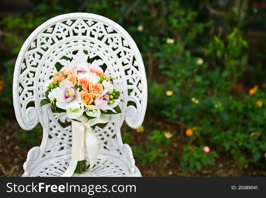 Wedding flower bouquet on a white garden chair, during a wedding