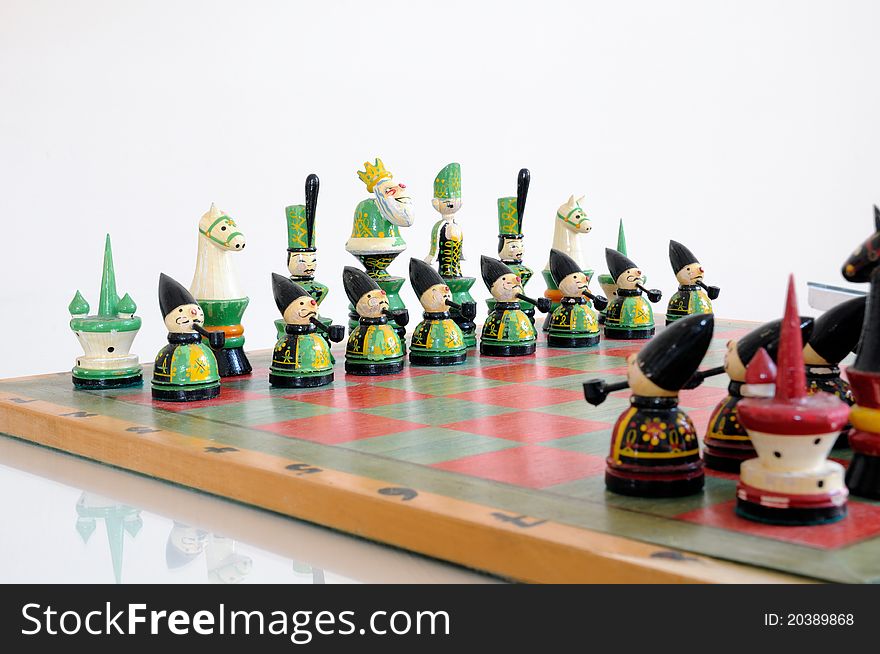 Colorful chess pieces on wood board