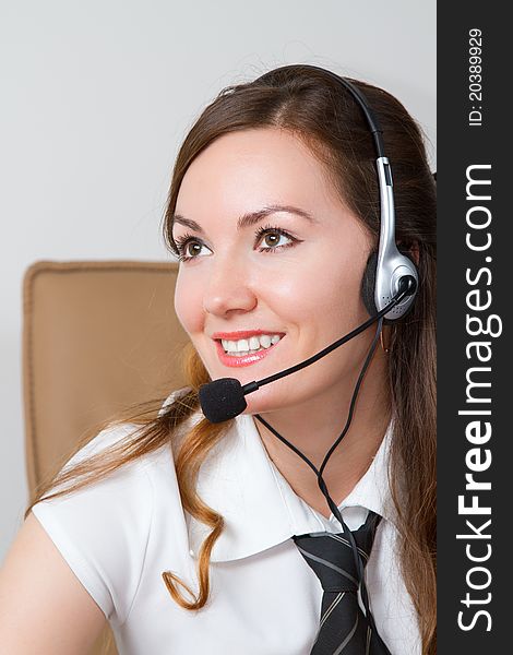 Business woman talking in a tie with headphones in the office. Business woman talking in a tie with headphones in the office