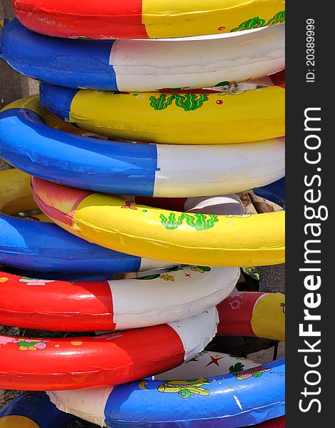 Colorful life buoy in stack under sun lighting, shown as sea beach holidy things and beautiful color and ring shape. Colorful life buoy in stack under sun lighting, shown as sea beach holidy things and beautiful color and ring shape.