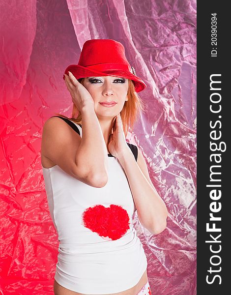 Pretty woman in red hat in studio