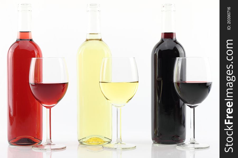 Three colors of wine in bottles and glasses