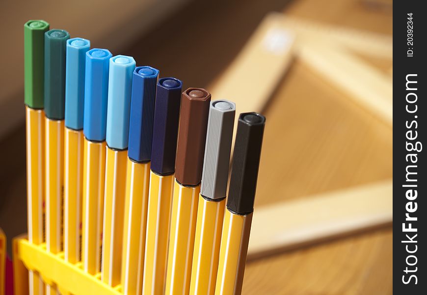 A set of colored pens, in the background square. A set of colored pens, in the background square.