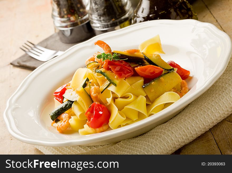 Photo of delicious italian pasta with zucchini and shrimps