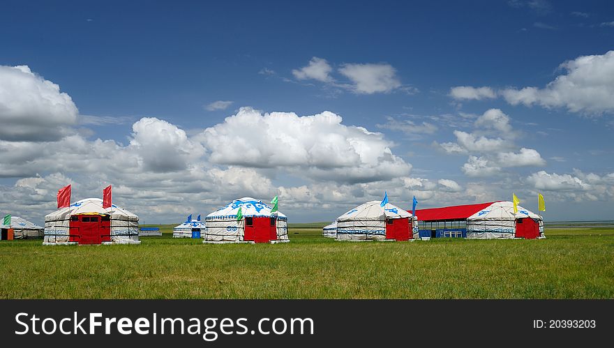 Red Yurts on the grassland under blue sky and white clouds in the north of China, beautiful.