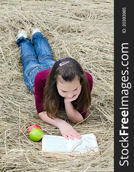 The girl with an apple on grass
