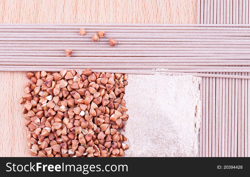 Buckwheat, buckwheat flour, buckwheat noodles on wooden background. Buckwheat, buckwheat flour, buckwheat noodles on wooden background