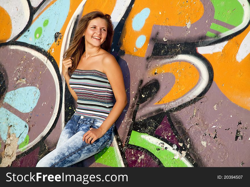 Girl near graffiti wall background.