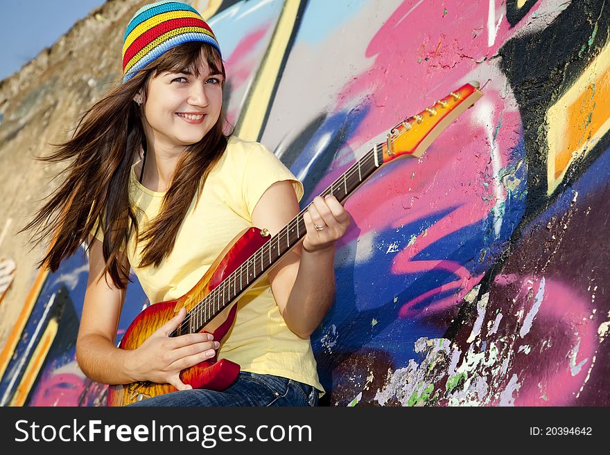 Girl with guitar and graffiti wall