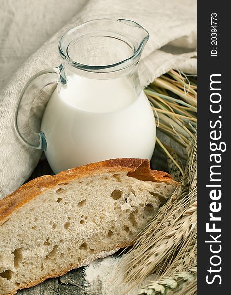 Piece of bread with jug of milk and spikes of rye. Piece of bread with jug of milk and spikes of rye