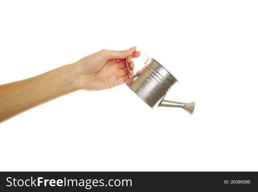 Close-up of female hand with an iron watering can. Isolated on a white background. Close-up of female hand with an iron watering can. Isolated on a white background