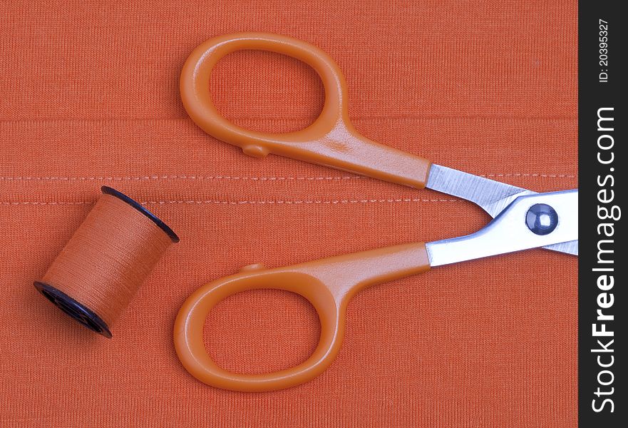 Scissors and threads on fabric background. Scissors and threads on fabric background