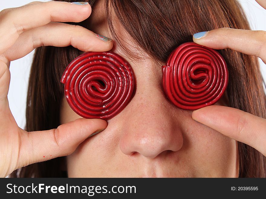 Girl with red candy sweets on her eyes. Girl with red candy sweets on her eyes