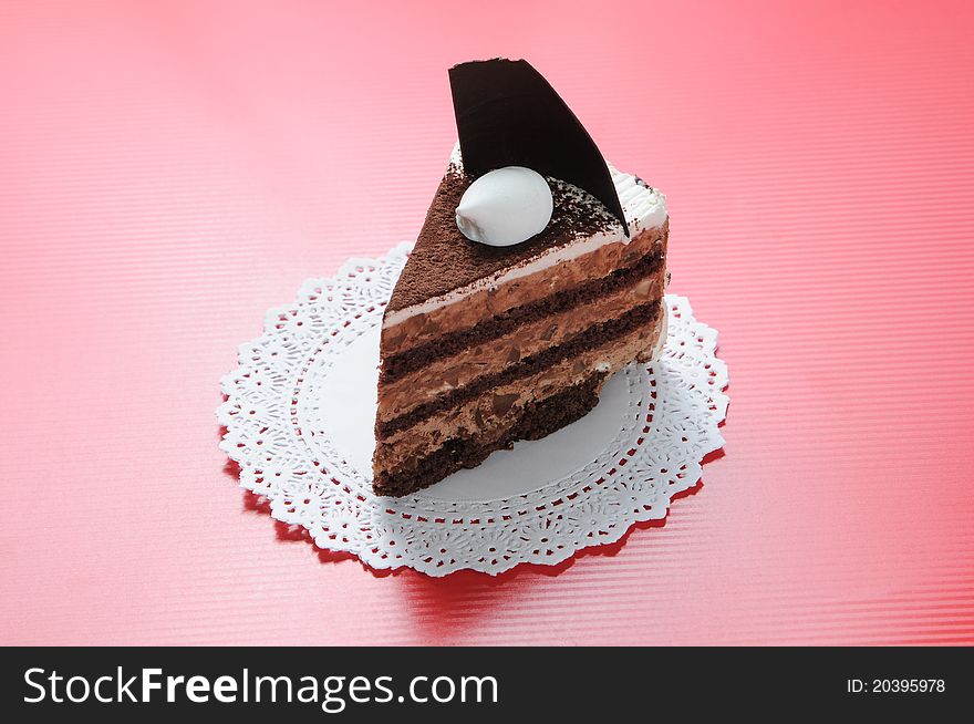 Chocolate shortcake with round white paper on red background. Chocolate shortcake with round white paper on red background