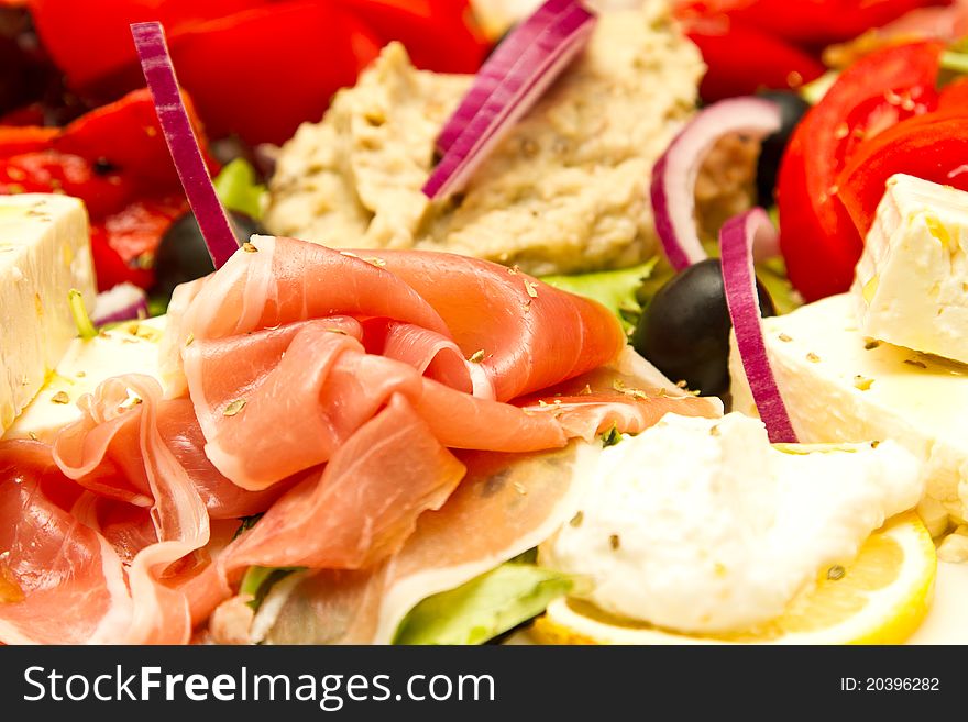 Appetizer of mixed meat, vegetables and cheese (shallow DOF)