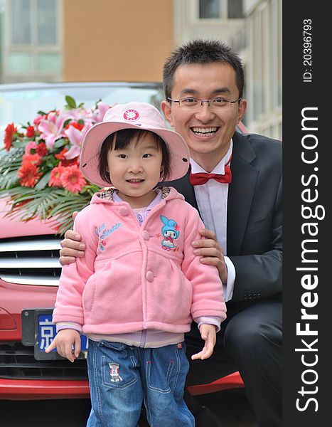 Happy Pink Asian Baby girl and man with pink cap photoes with the Wedding car. The man hold the girl. They both feel happy. Happy Pink Asian Baby girl and man with pink cap photoes with the Wedding car. The man hold the girl. They both feel happy.