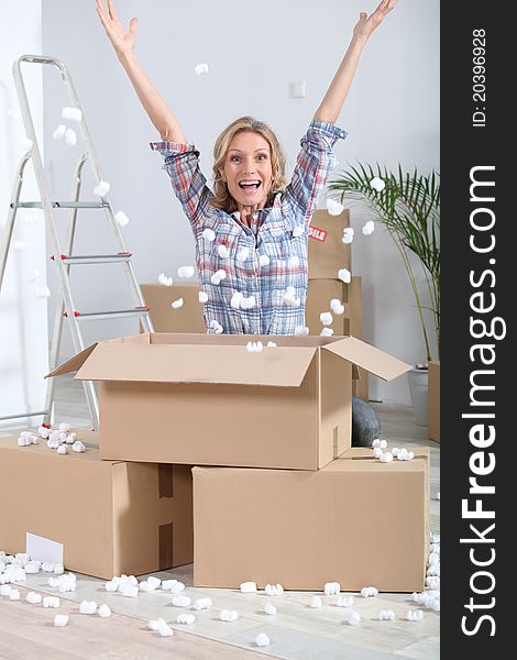 Woman crouching in front of stacked cardboard boxes. Woman crouching in front of stacked cardboard boxes