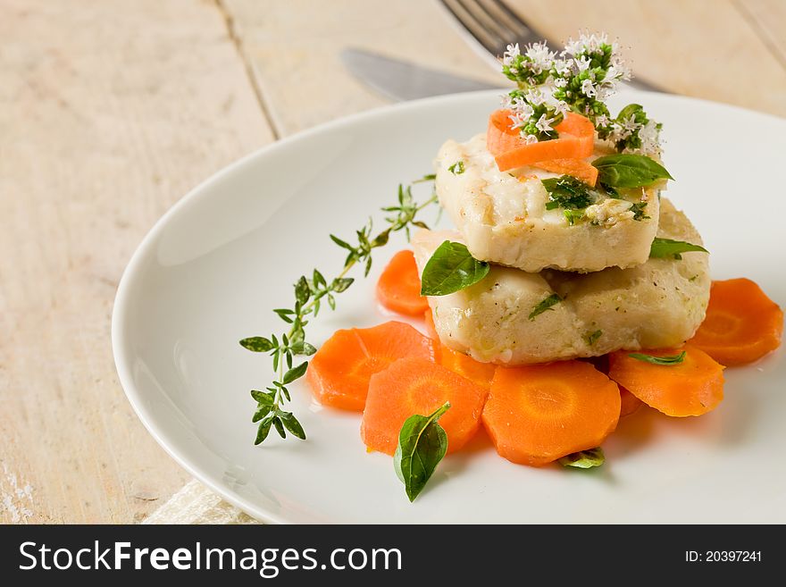 Photo of delicious cod over carrots with fresh oregano and basil. Photo of delicious cod over carrots with fresh oregano and basil