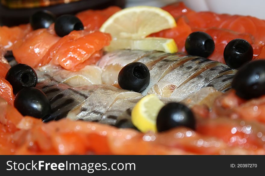 Sliced on a platter trout and mackerel, decorated with lemon and olives. Sliced on a platter trout and mackerel, decorated with lemon and olives