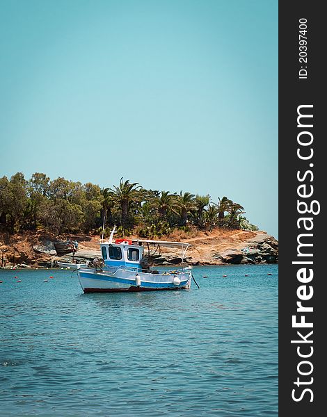 A picture of a small fishing boat standing near the coast of the sea. A picture of a small fishing boat standing near the coast of the sea.