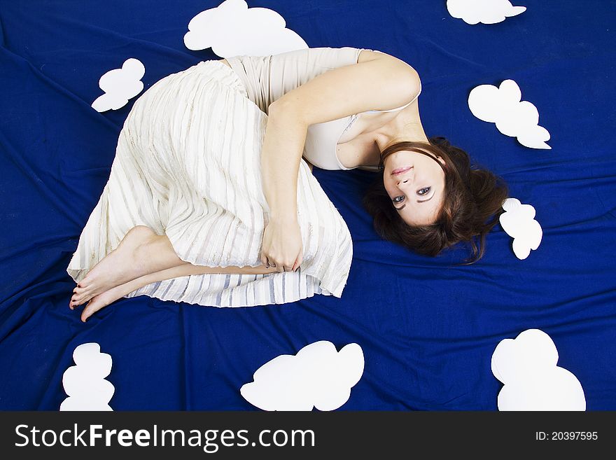 Young beautiful girl lying in the sky with clouds