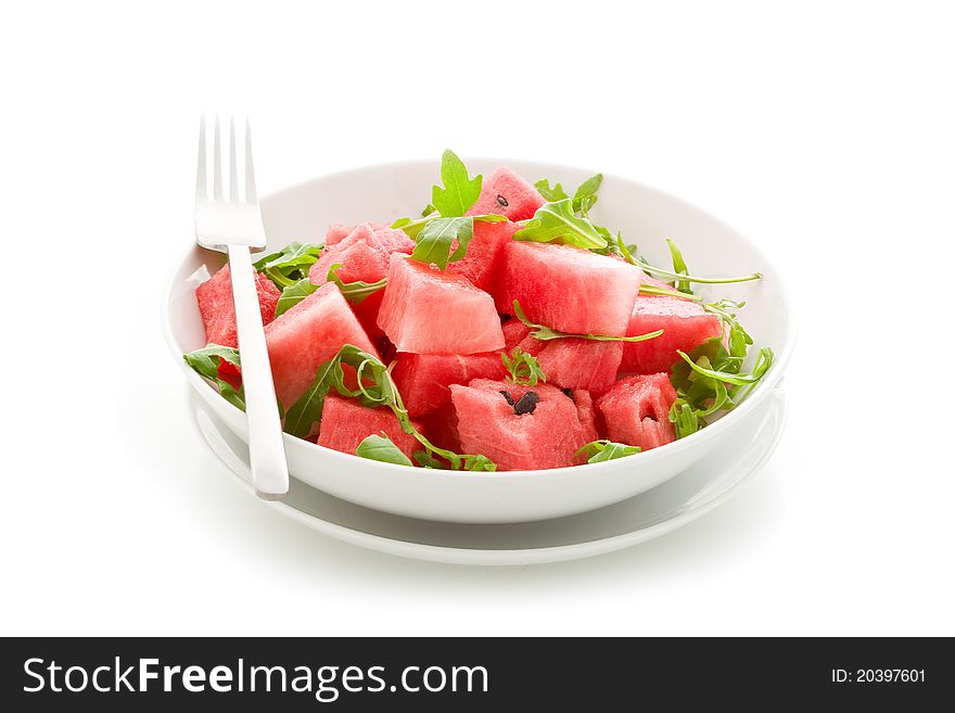 Photo of delicious fresh watermelon and arugula salad on isolated background. Photo of delicious fresh watermelon and arugula salad on isolated background