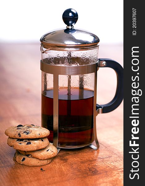 Teapot with chocolate cookies on the wooden table. Teapot with chocolate cookies on the wooden table