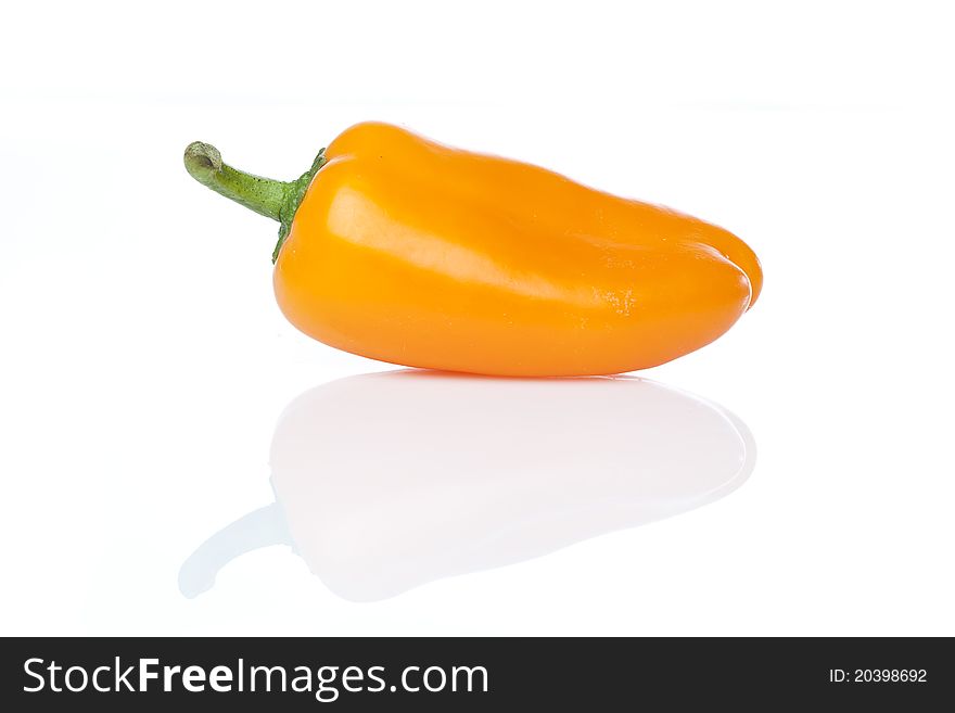 An orange baby pepper against a white background