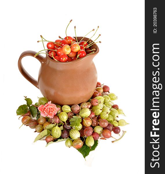 Jug with a sweet cherry among berries сurrant and a gooseberry