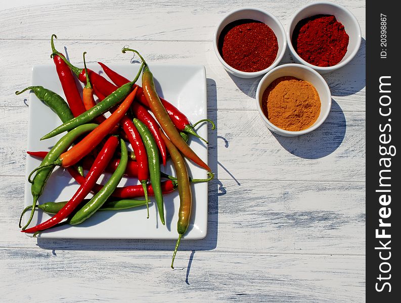 Assorted Chillies Ground and Live on White Rustic Background. Assorted Chillies Ground and Live on White Rustic Background