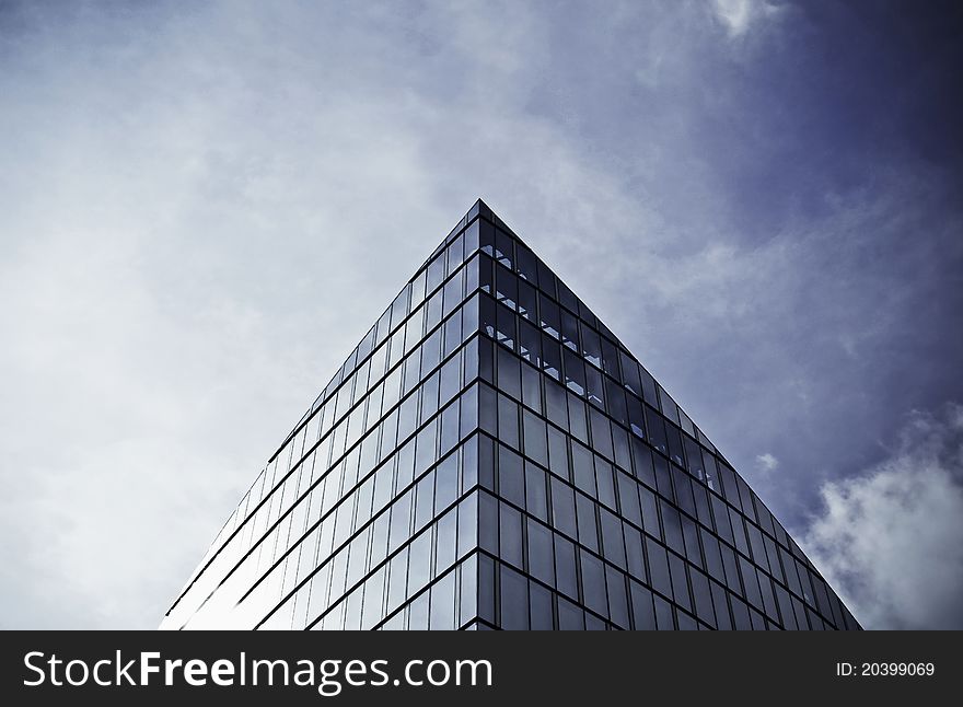 Shot of the glass skyscraper roof on the back of beautiful sky. Shot of the glass skyscraper roof on the back of beautiful sky