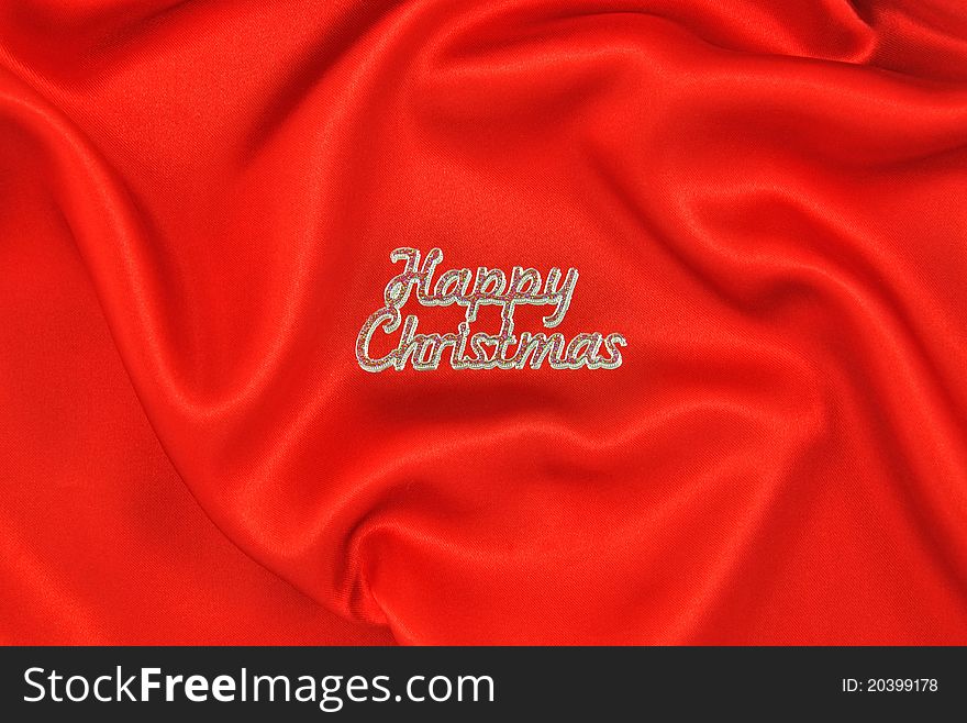 Crumpled red satin cloth with Happy Christmas message. Crumpled red satin cloth with Happy Christmas message